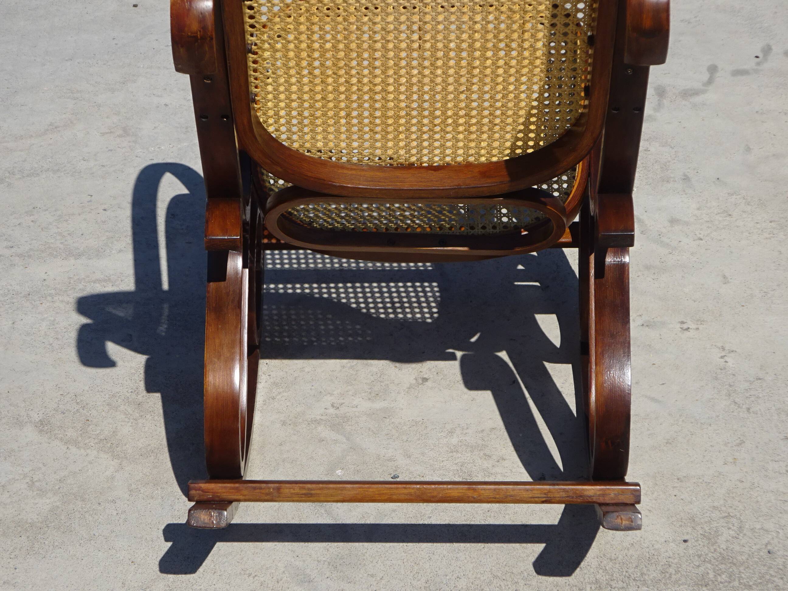 Vintage wooden rocking chair with caning