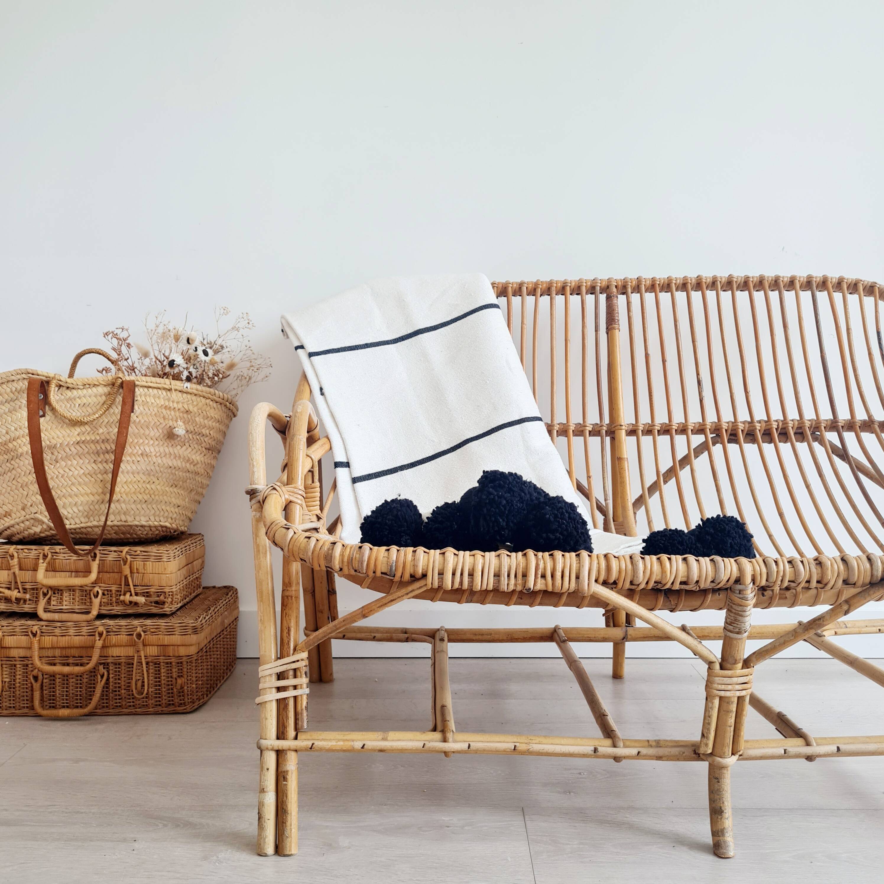 Handwoven throw with black stripes and pom-poms