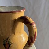 Large antique handmade ochre yellow jug with a pink flower pattern.