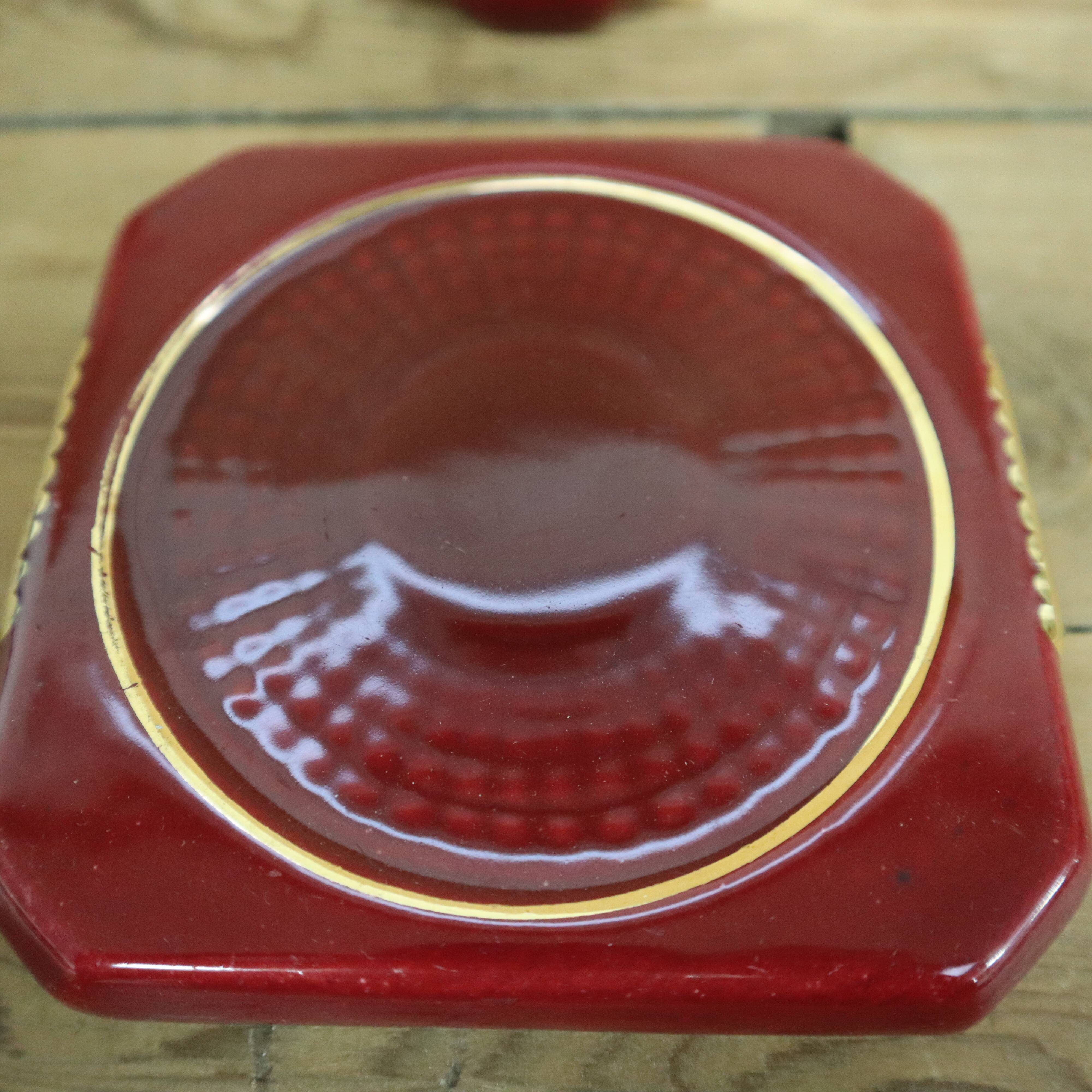 Pair of burgundy ceramic coasters or bottles with gold trim