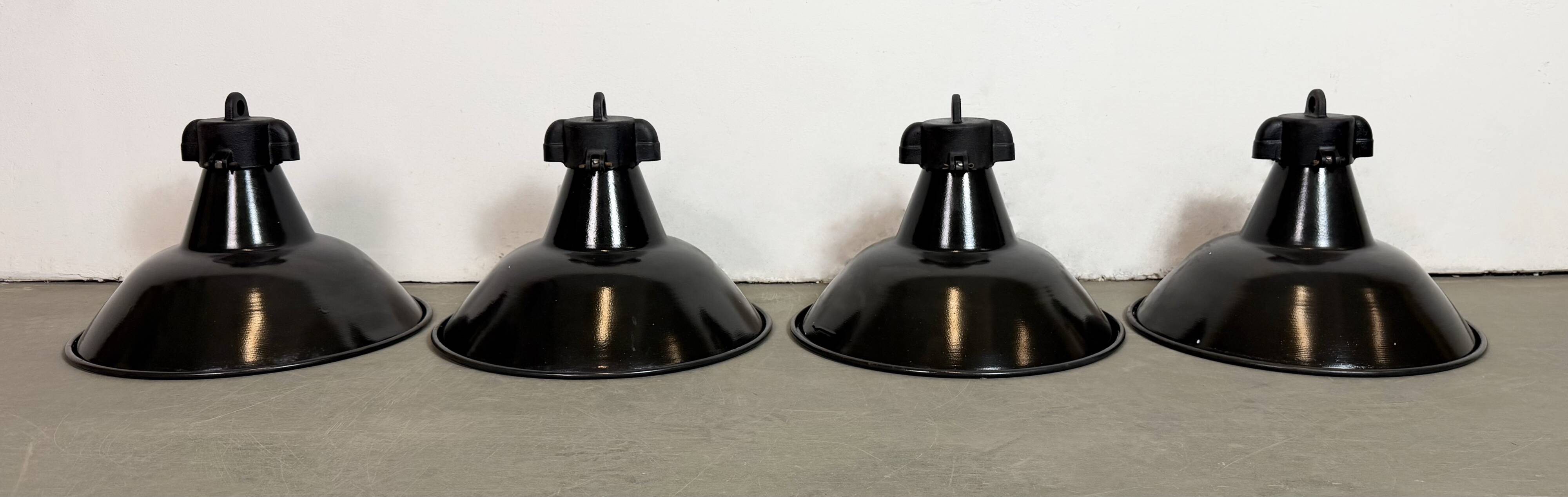 Ensemble de 4 lampes d'usine en émail noir industriel avec dessus en fonte, années 1950.