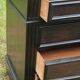 Blackened wooden chest of drawers with 5 drawers