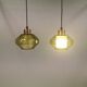 Hanging lamp with an outer shade of olive green glass and an inner shade of clear, crystal glass.