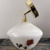 Golden tilting wall light with flowered globe
