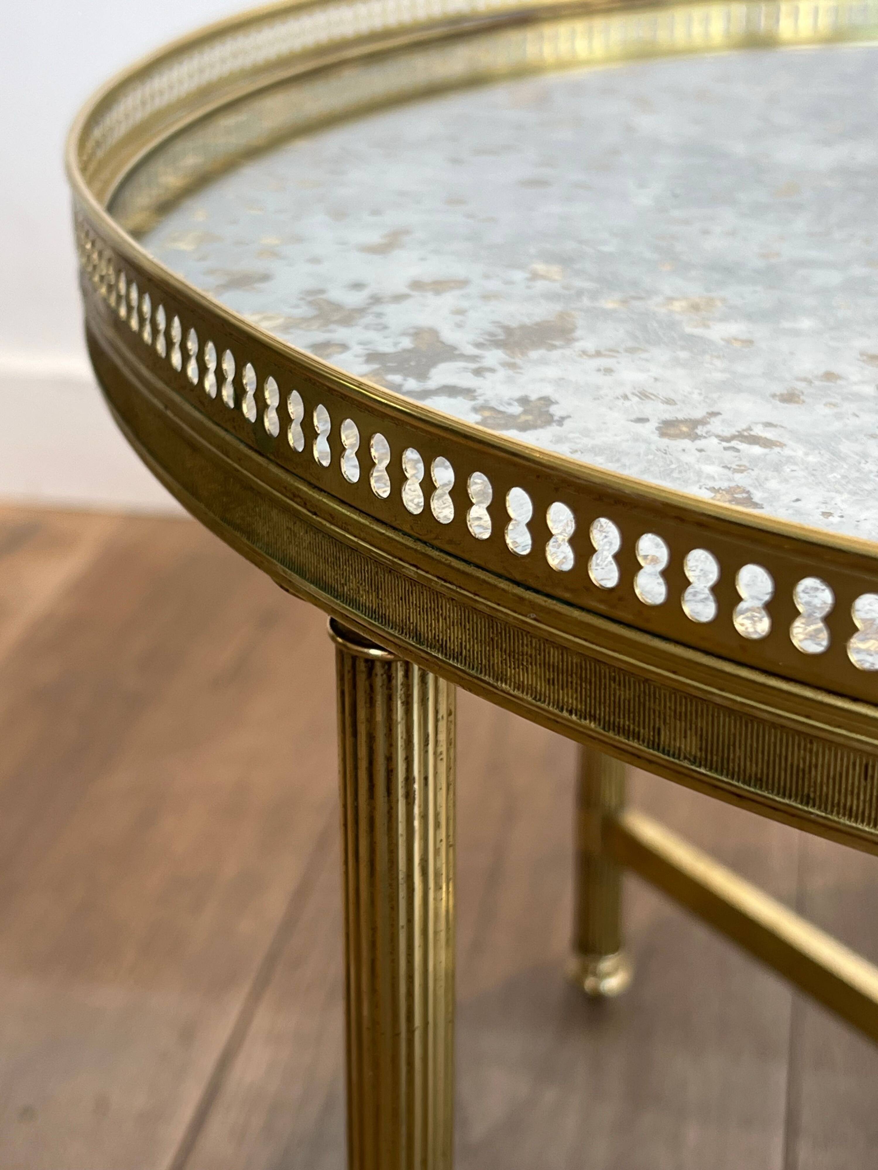 Brass coffee table with a vintage mirror top from the Baguès house.