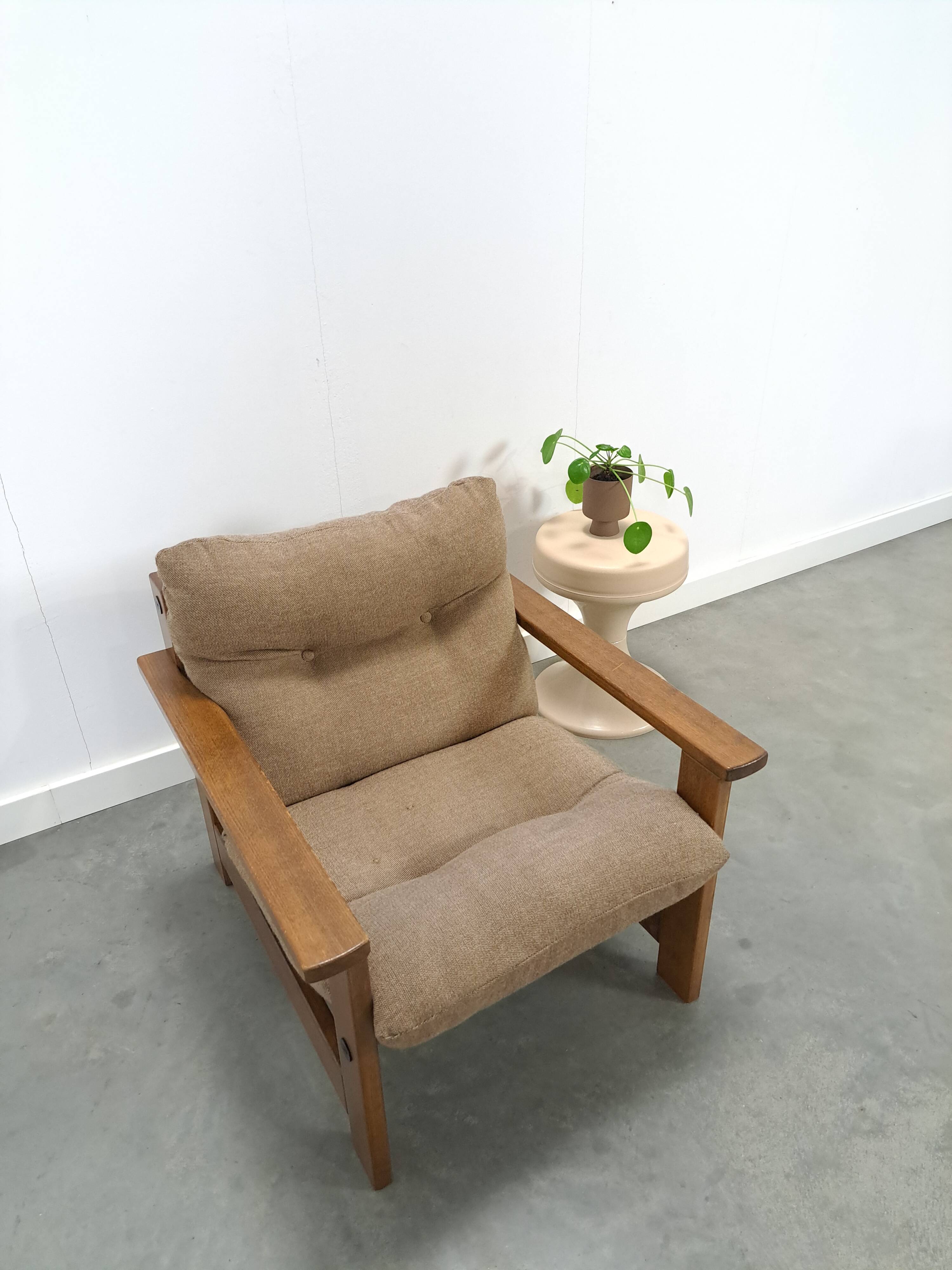 Brown-grey armchair with an oak frame.