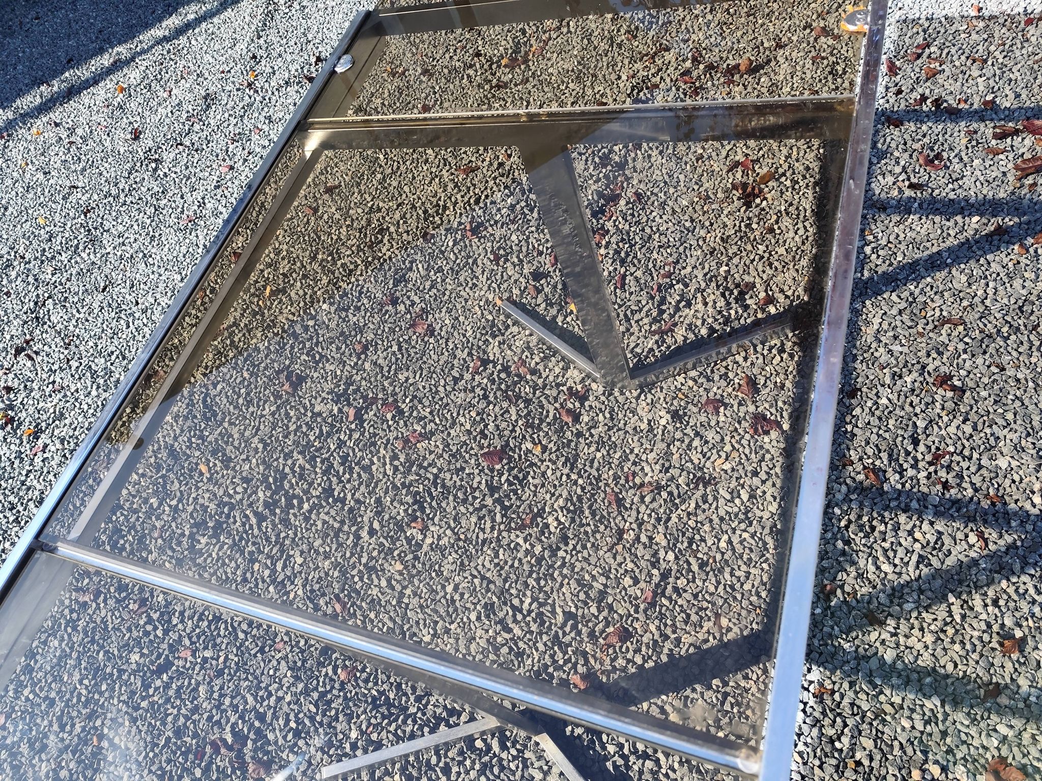 Table pietement chromé et verre fumé année 70 avec allonges