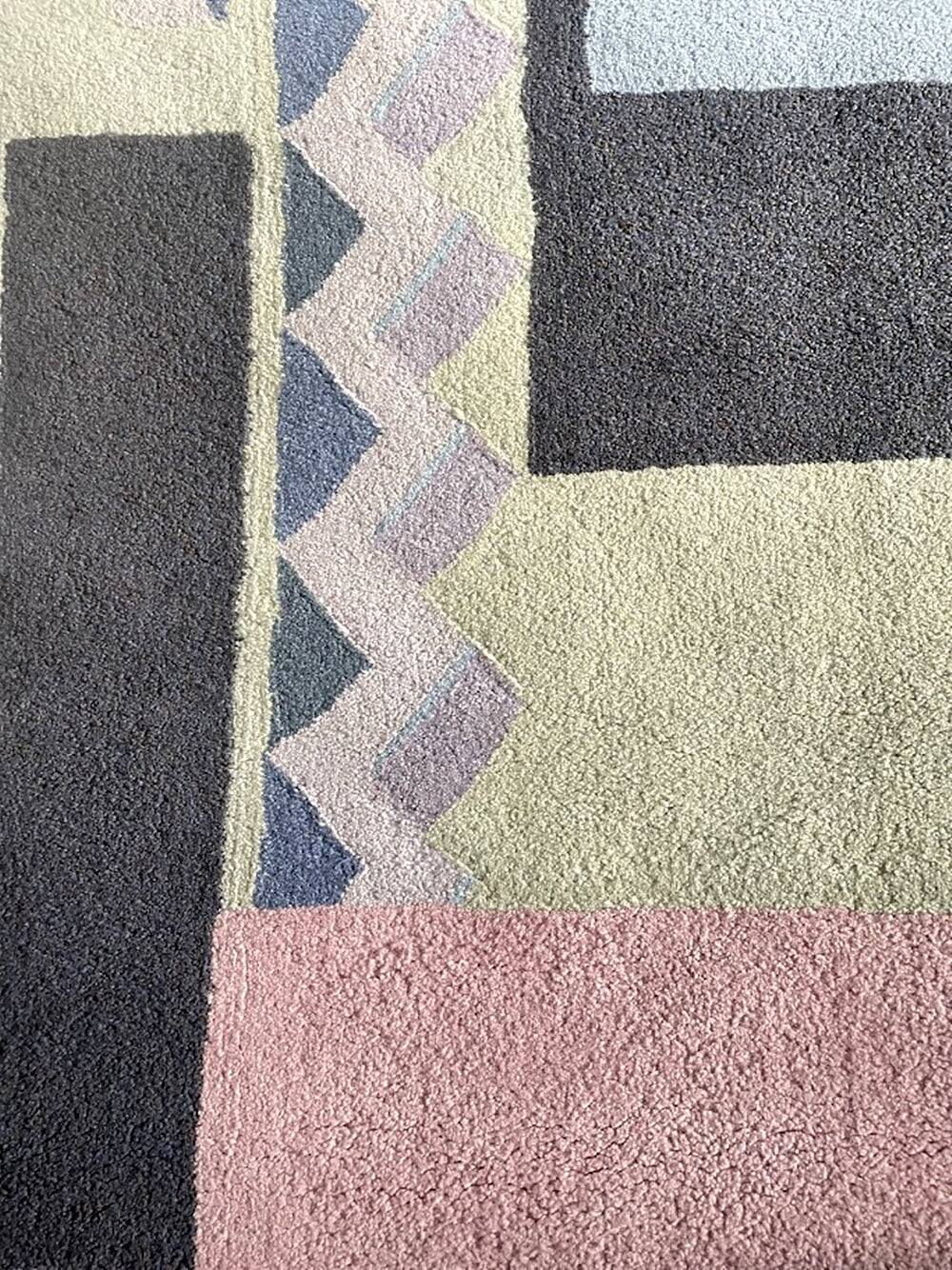 Hand-knotted wool rug by Tisca with a geometric pattern, signed "ILES", France, 1990s.