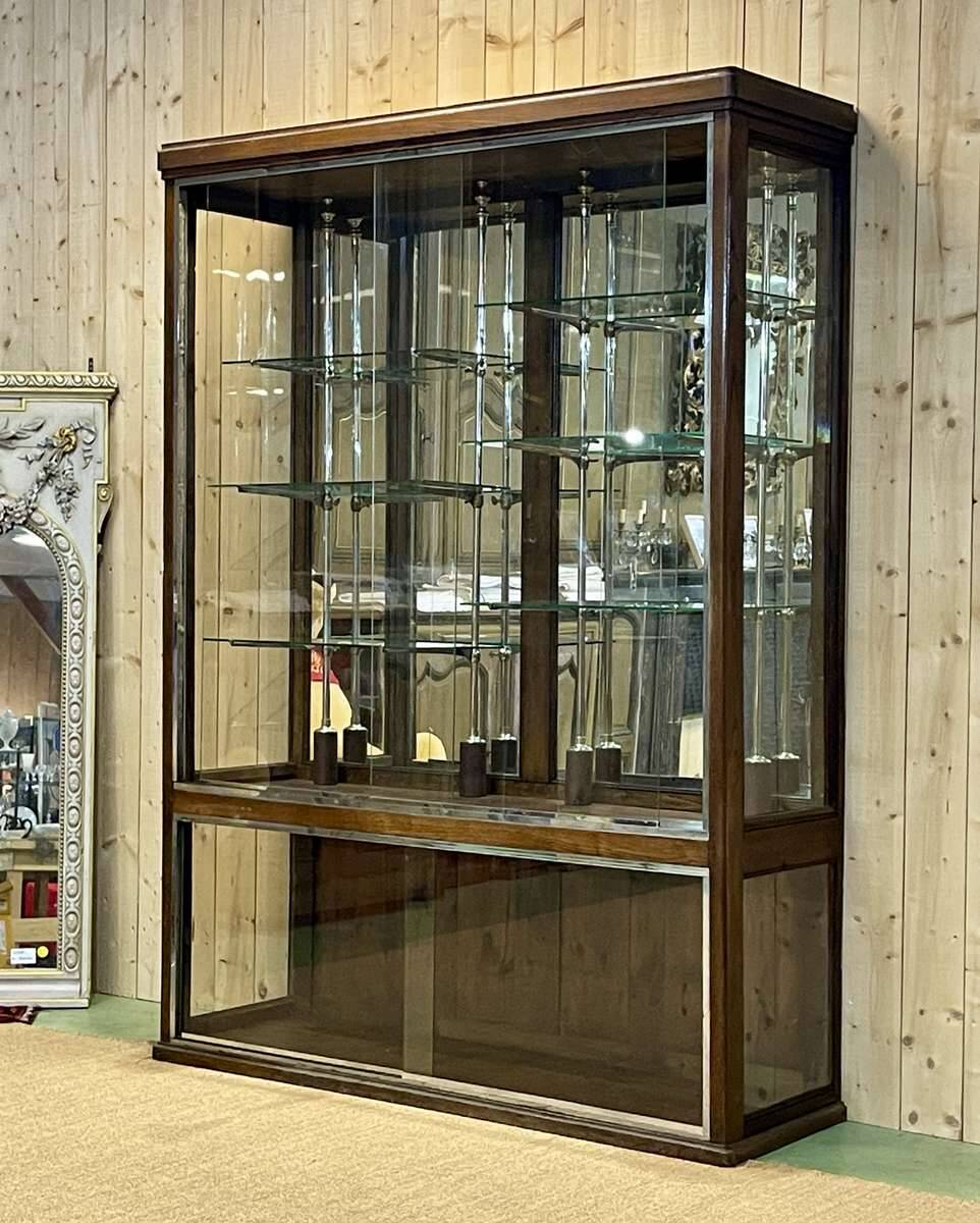 Early 20th-century shop display cabinet in oak with sliding doors.