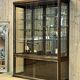Early 20th-century shop display cabinet in oak with sliding doors.