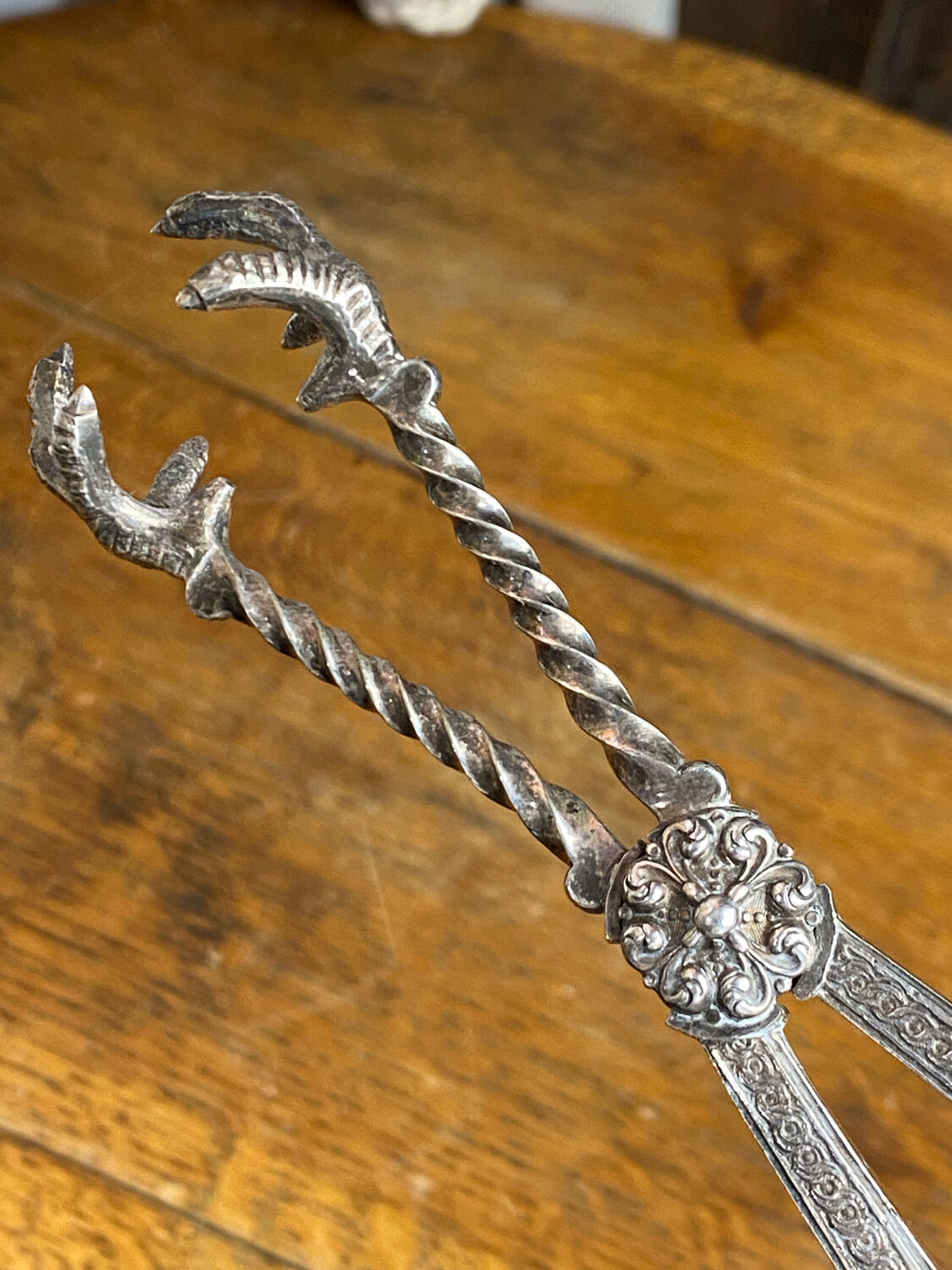 Sugar tongs or ice tongs in silver-plated metal.