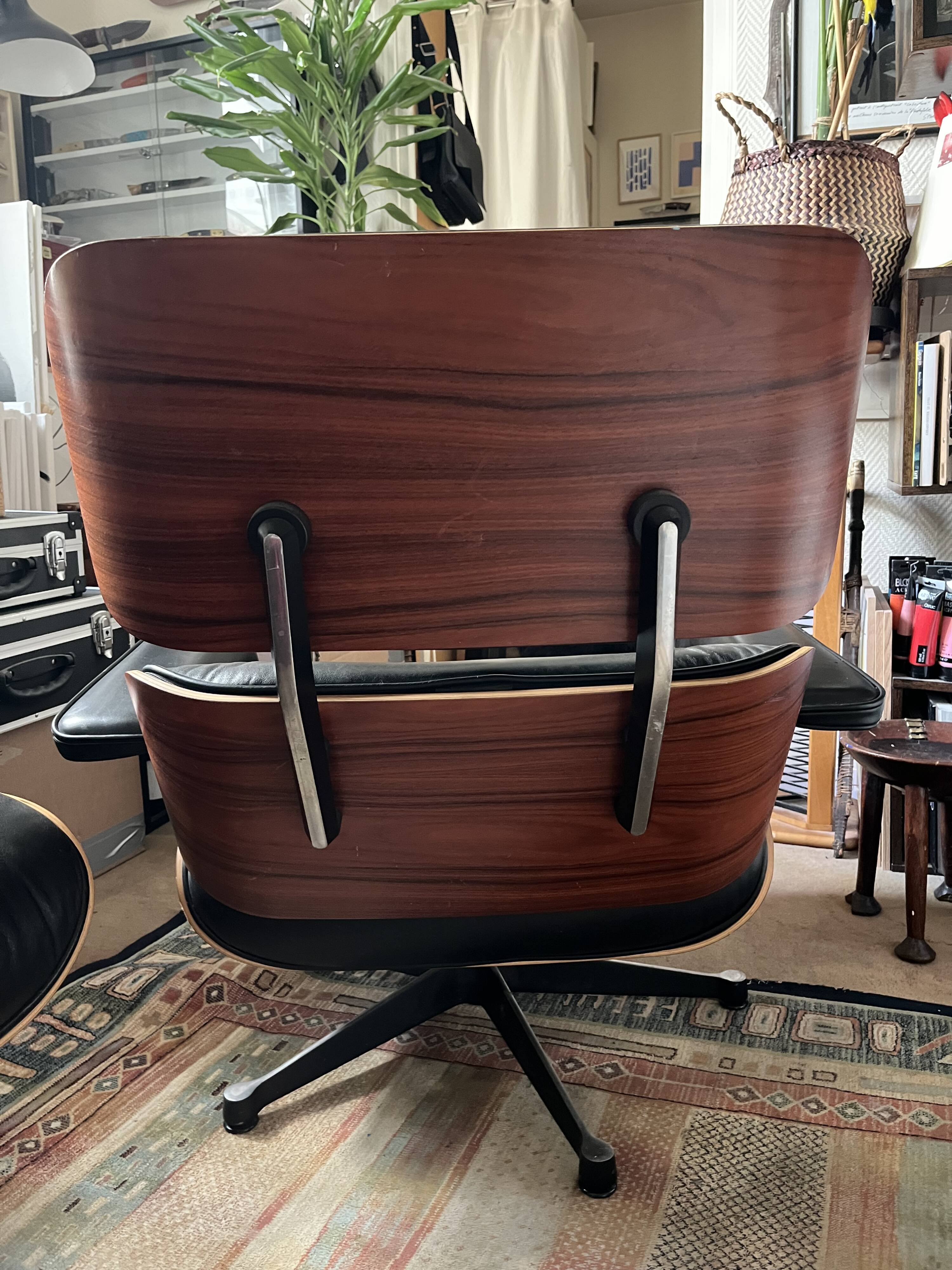 Black leather Eames Vitra armchair, original with rosewood ottoman.