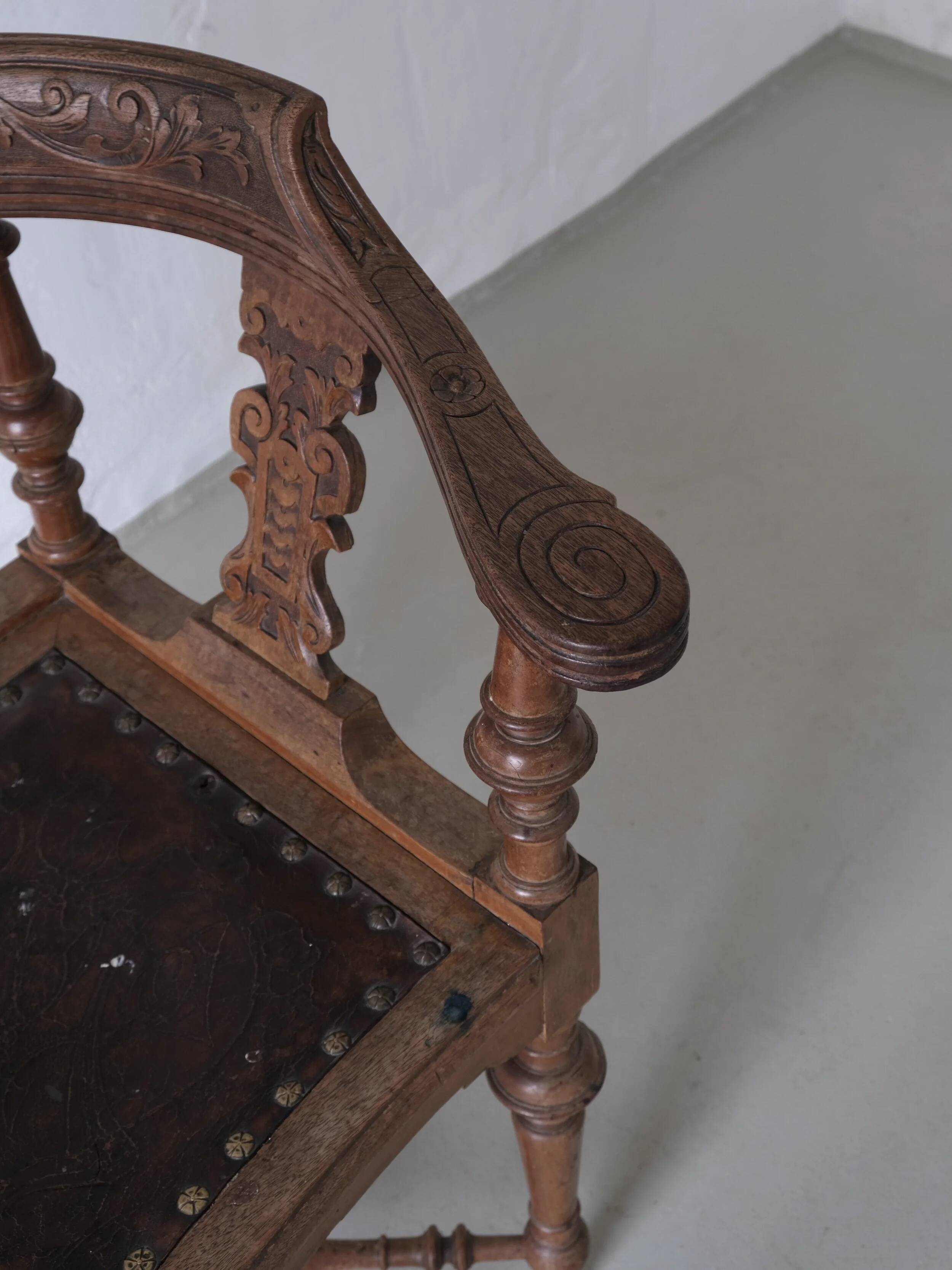 Fauteuil d'angle ancien sculpté avec assise en cuir