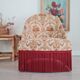Beige toad armchair with floral patterns and red fringes