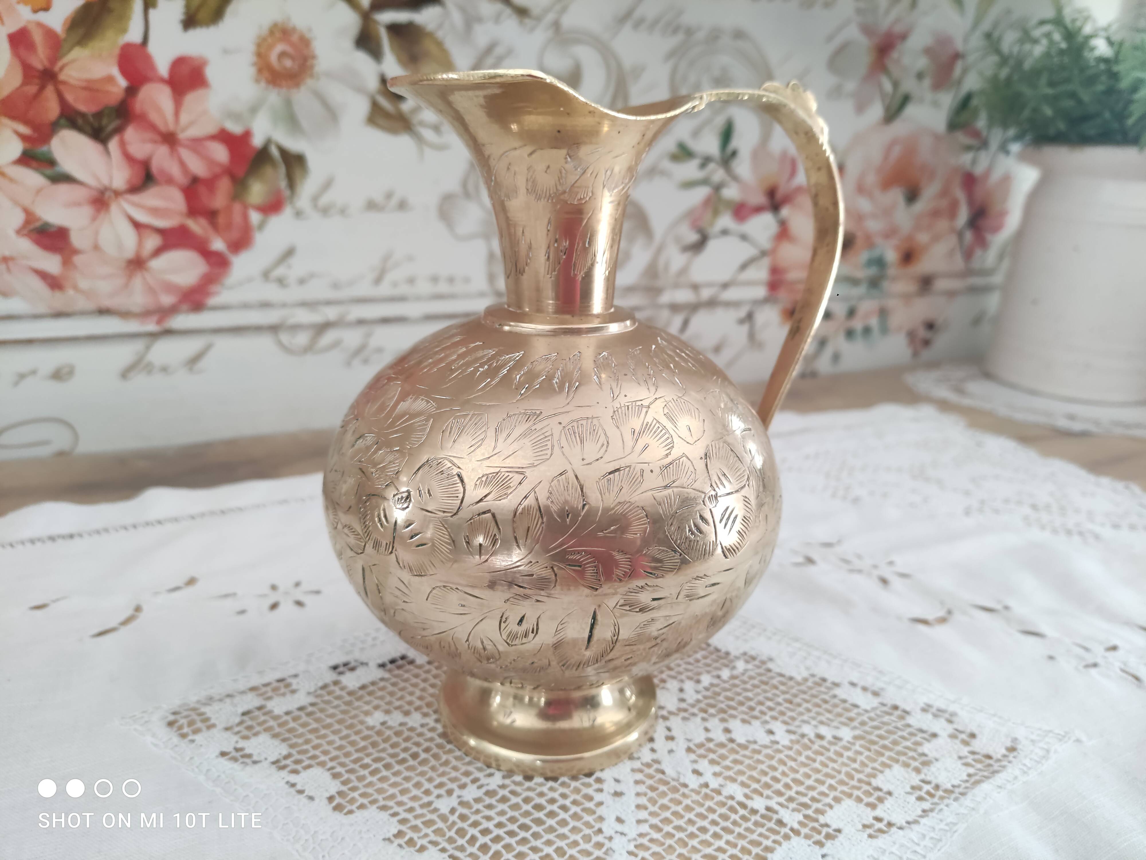 Chiseled brass pitcher decorated foliage