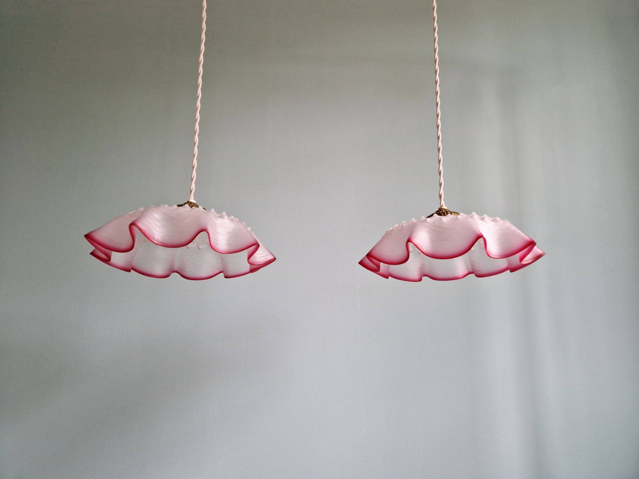 Pair of clear and pink satin glass scalloped pendant lights, 1920s-30s