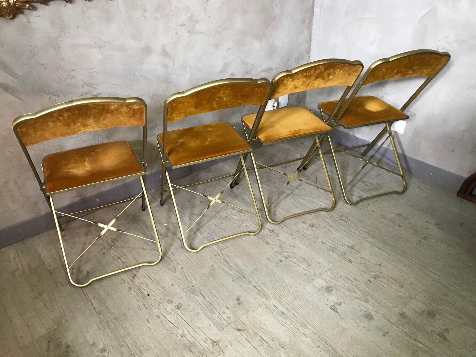 Four folding velvet and brass chairs