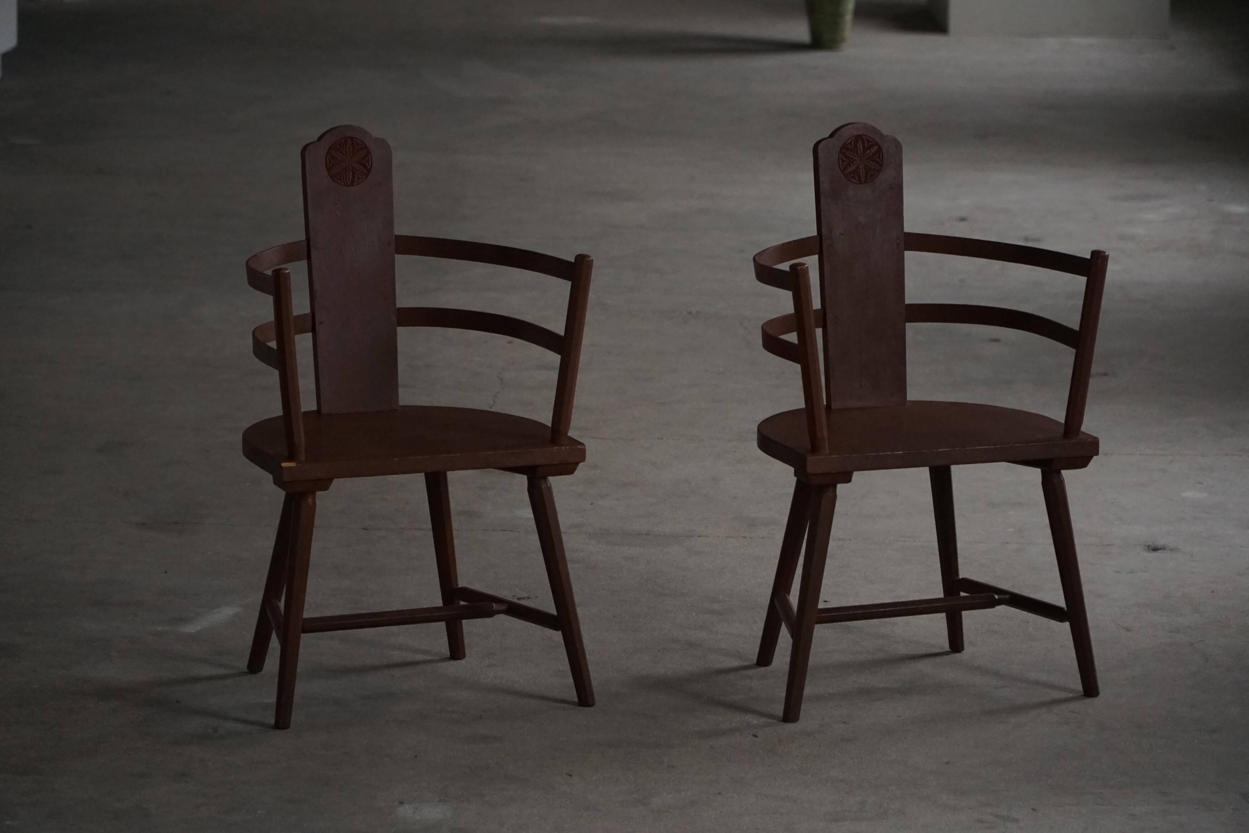 Pair of Scandinavian wooden armchairs with hand-carved folk motifs, 1920s.