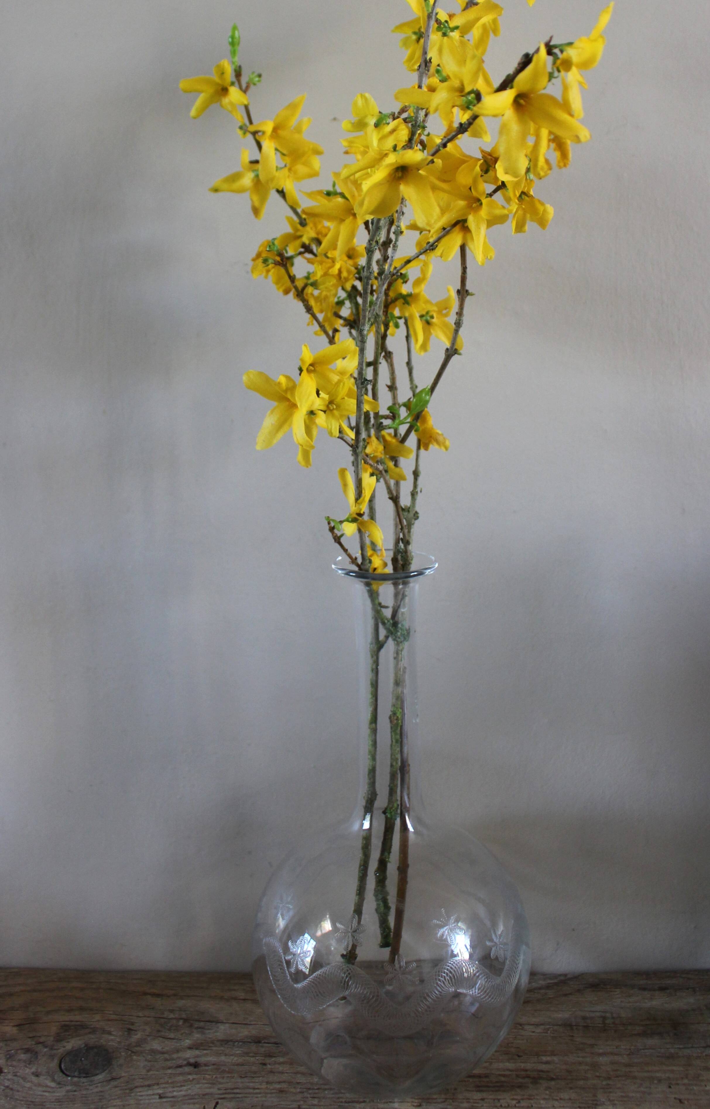Antique glass carafe with a round belly and floral neck.