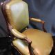 Paire de larges fauteuils XIXe en cuir vert de style Louis XV