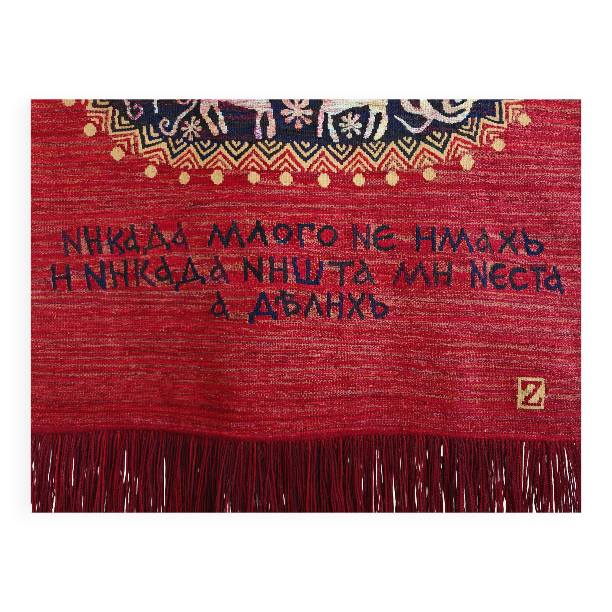 Vintage handwoven tapestry with a folk scene and archaic Slavic writing.