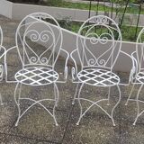 Folding round table and four wrought iron armchairs