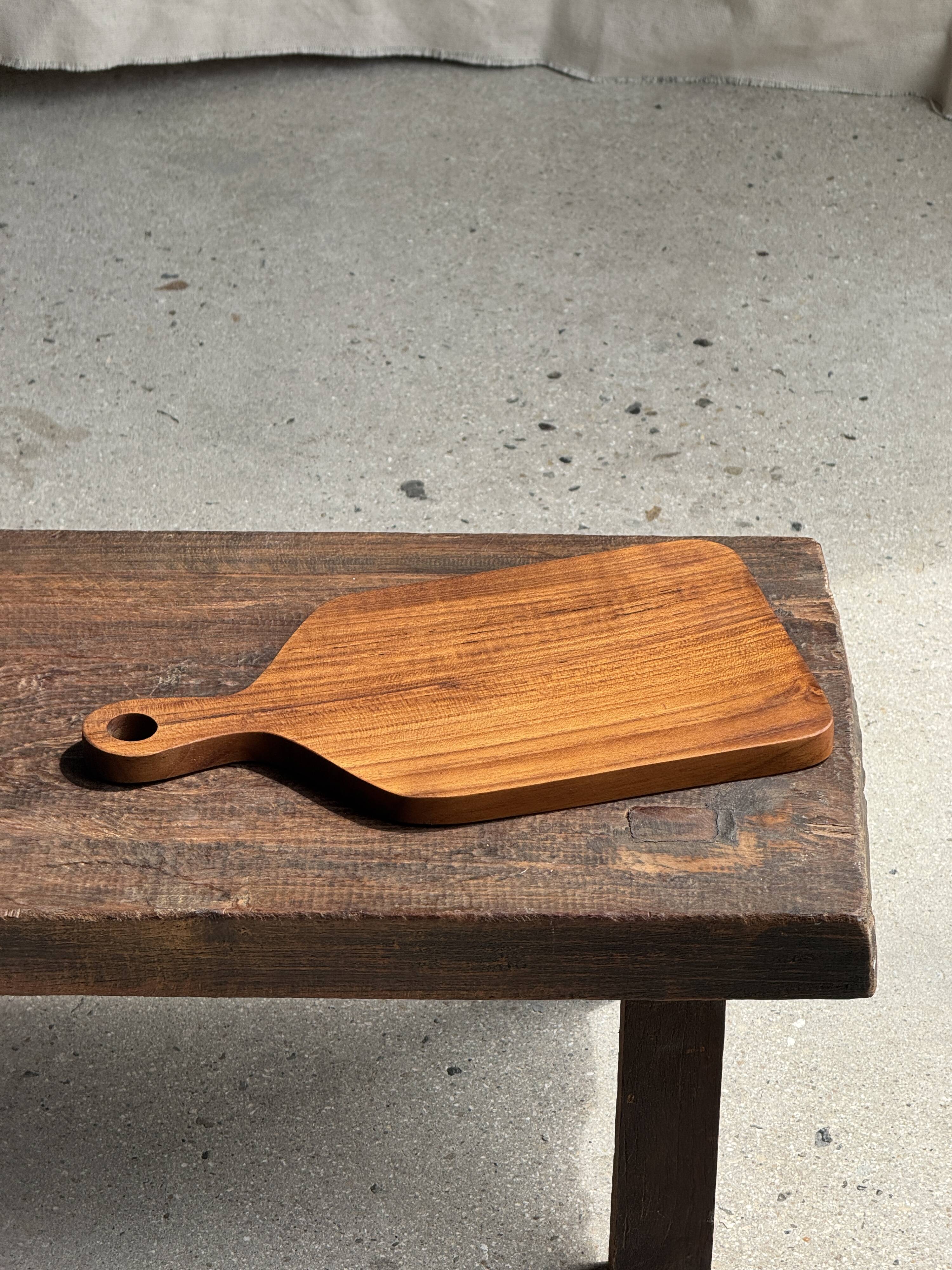 Rectangular solid teak chopping board with elongated handle 30x16.