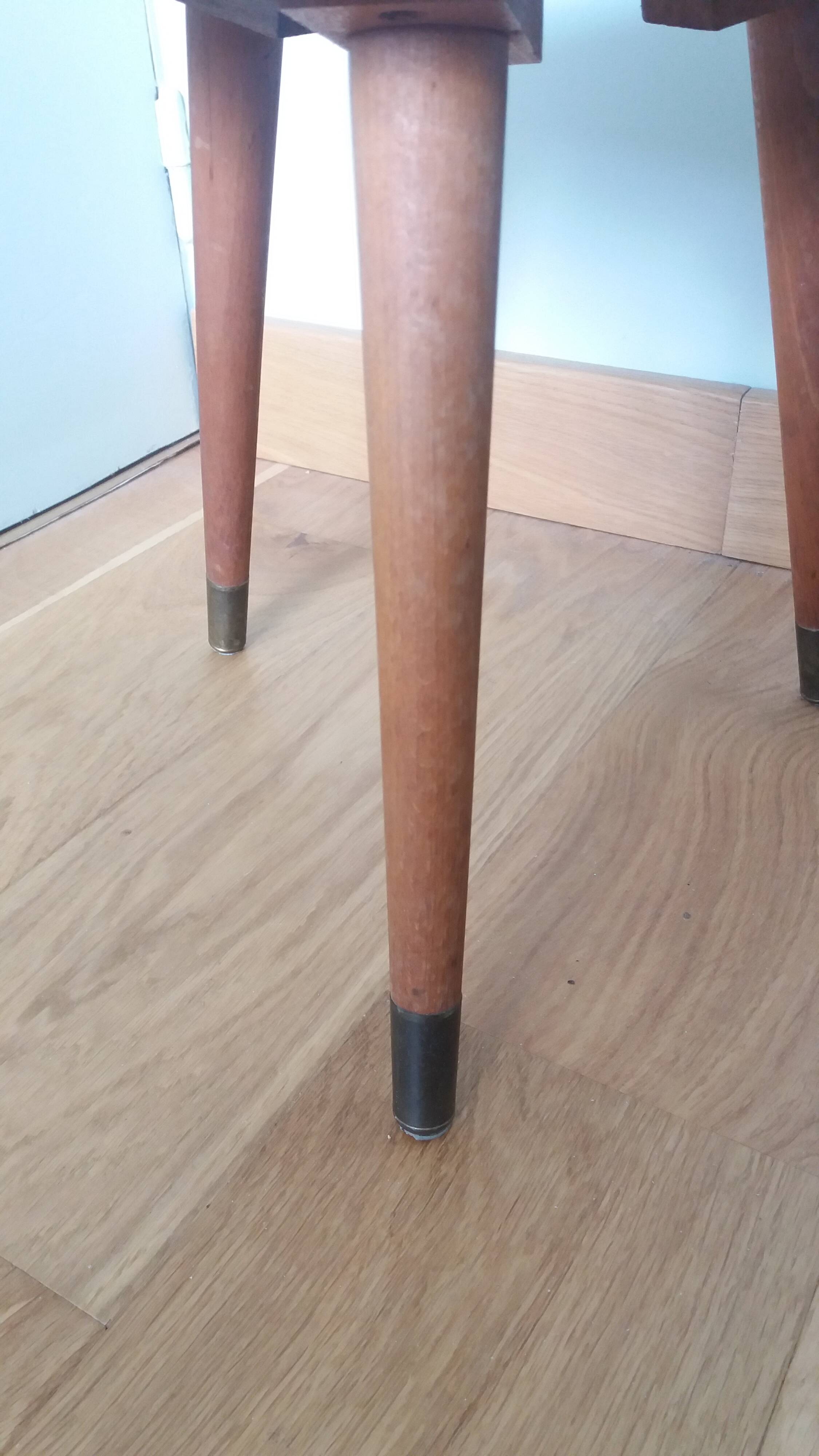 Tripod console table plant stand in the shape of a plectrum.