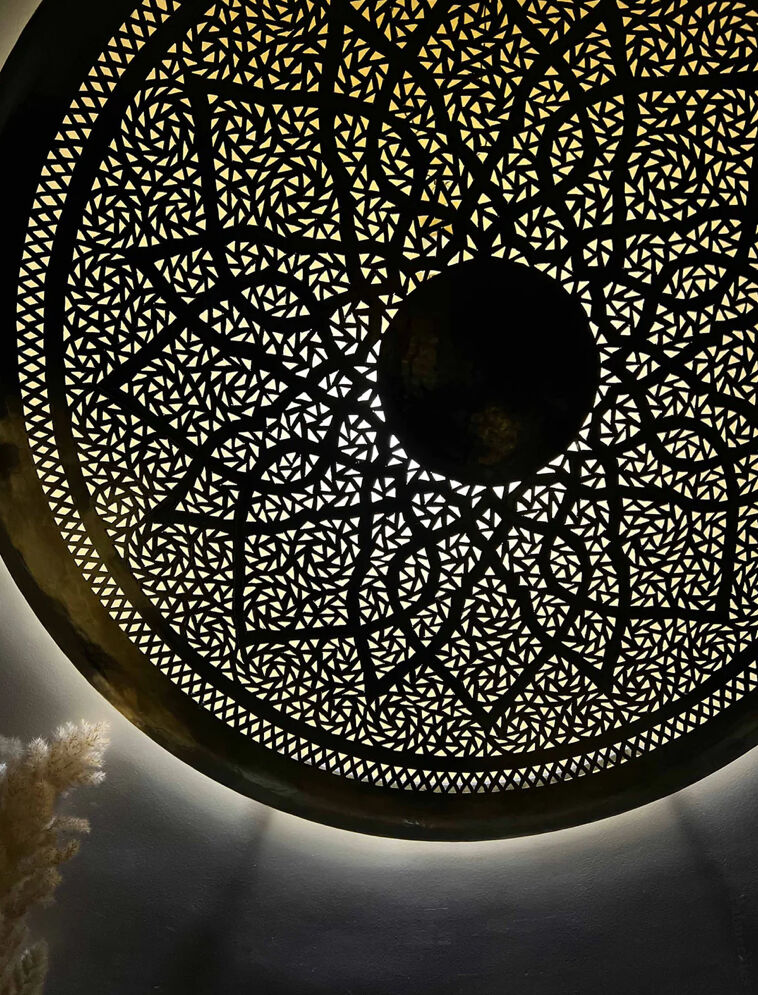 Large oriental wall lamp in hammered gold-plated perforated brass, 100 cm.