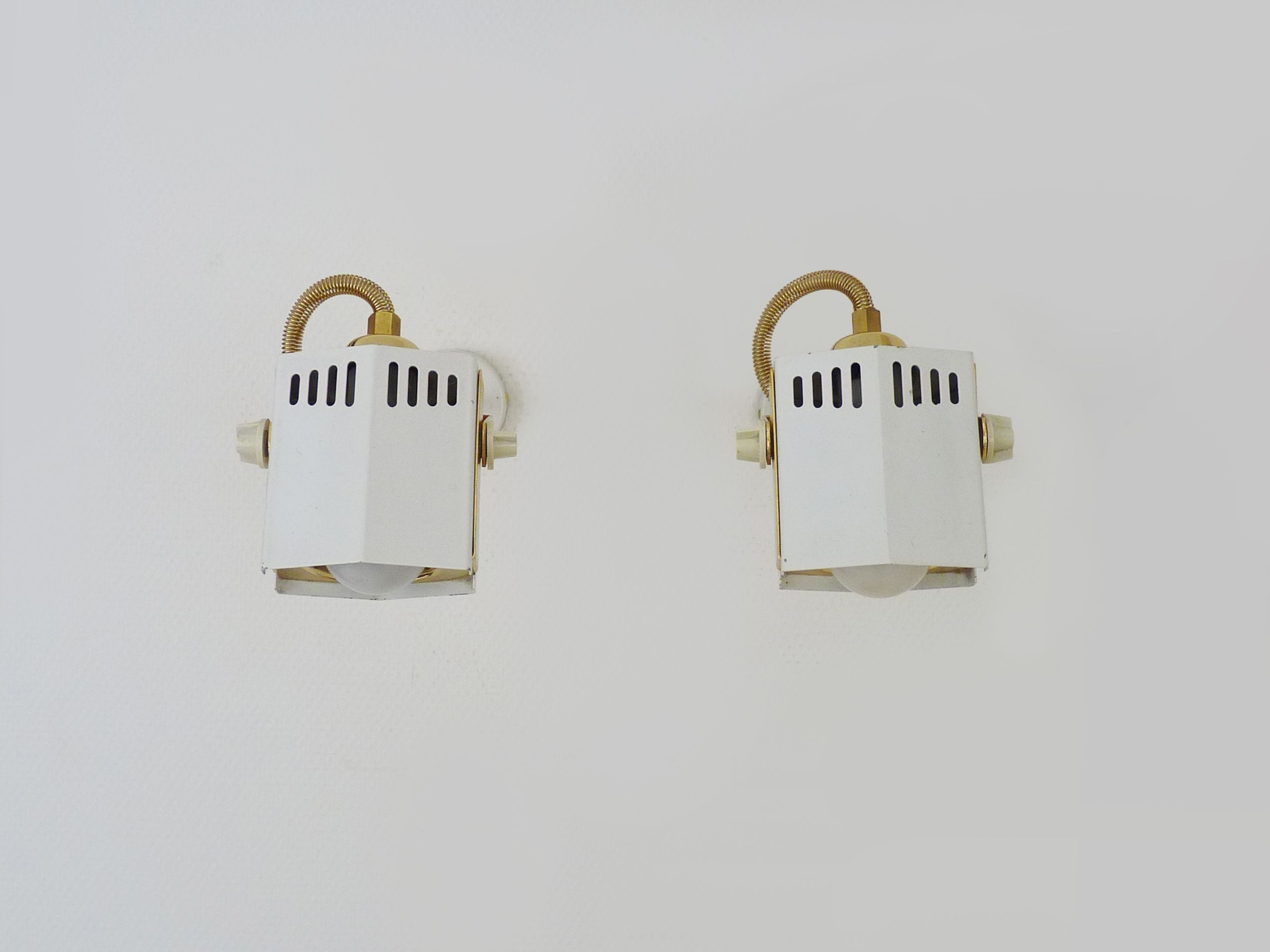 Pair of spot wall lamps adjustable design in white metal and brass. Year 80