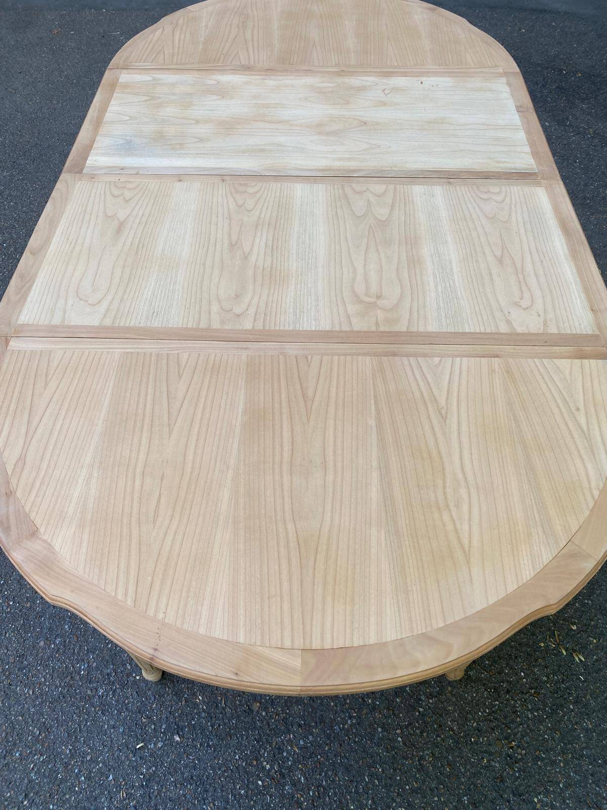 Extendable round table in renovated Louis XVI style, made of light wood, with 2 extensions.