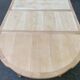 Extendable round table in renovated Louis XVI style, made of light wood, with 2 extensions.