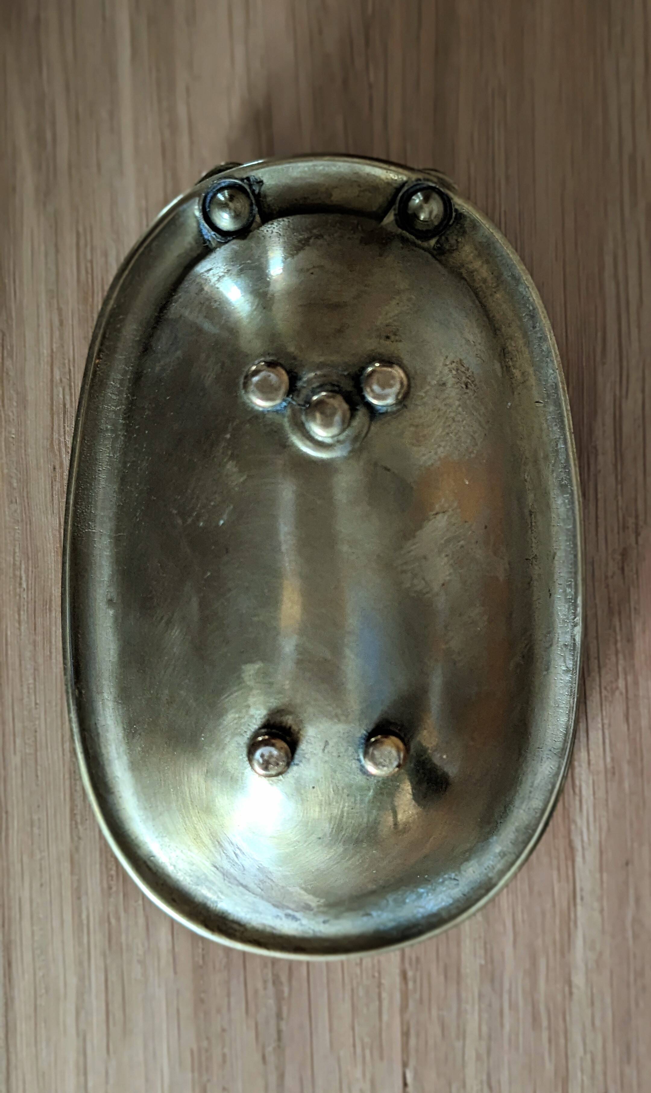 Old soap dish in the shape of a brass bathtub