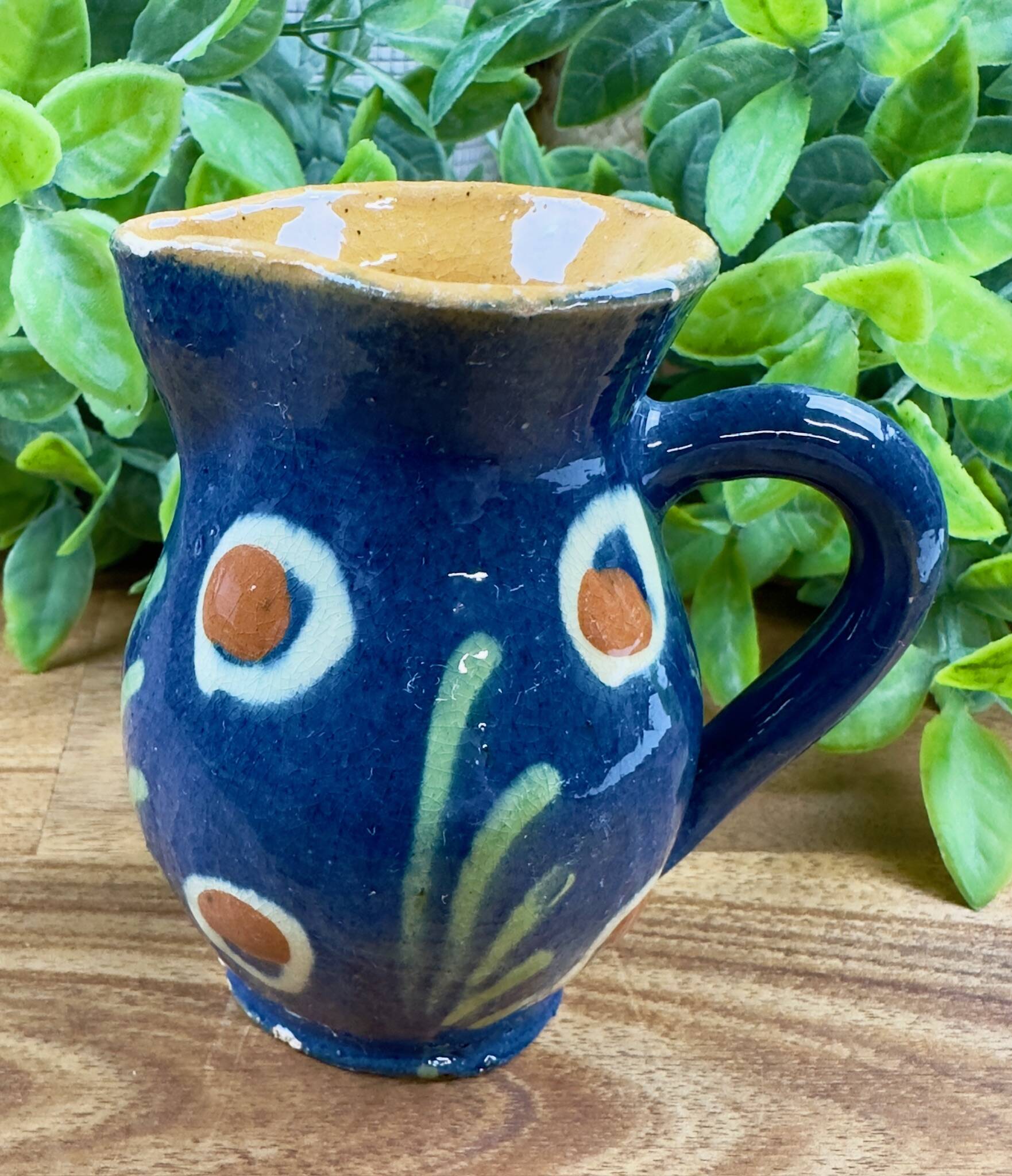 Small blue ceramic jug with hand-painted floral decoration, vintage.