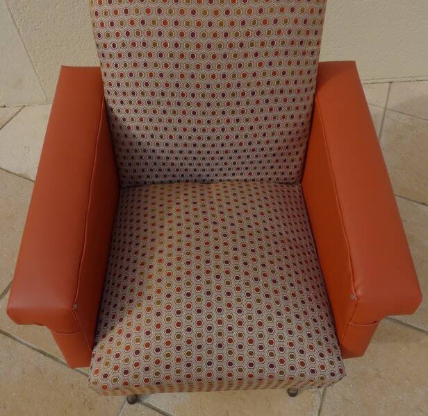 Vintage rockabilly retro armchair in orange faux leather and fabric.