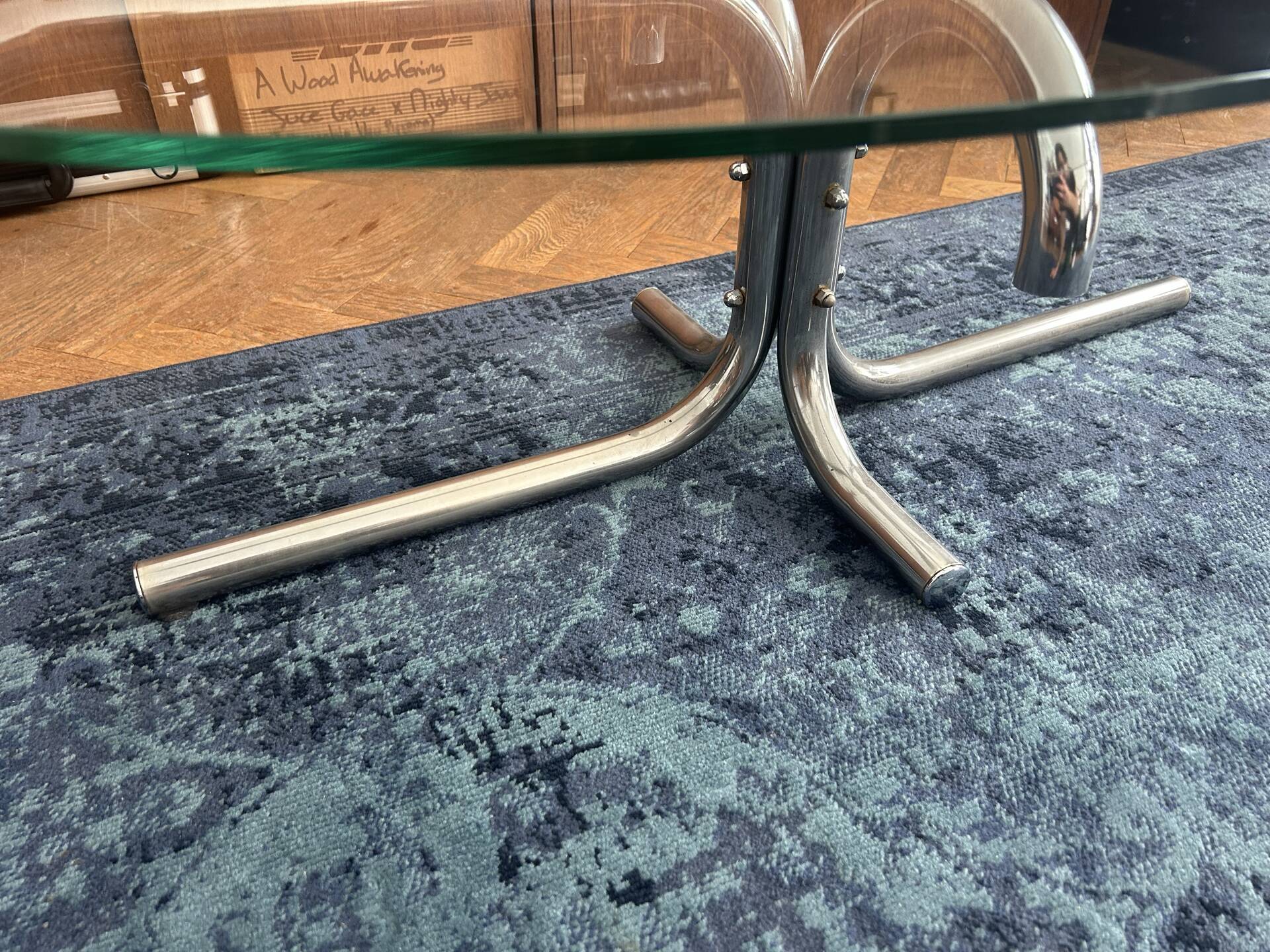 Oval glass coffee table with chrome legs, vintage 70s design.