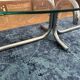 Oval glass coffee table with chrome legs, vintage 70s design.