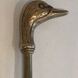 Neoclassical brass fire accessory with duck head decorations.