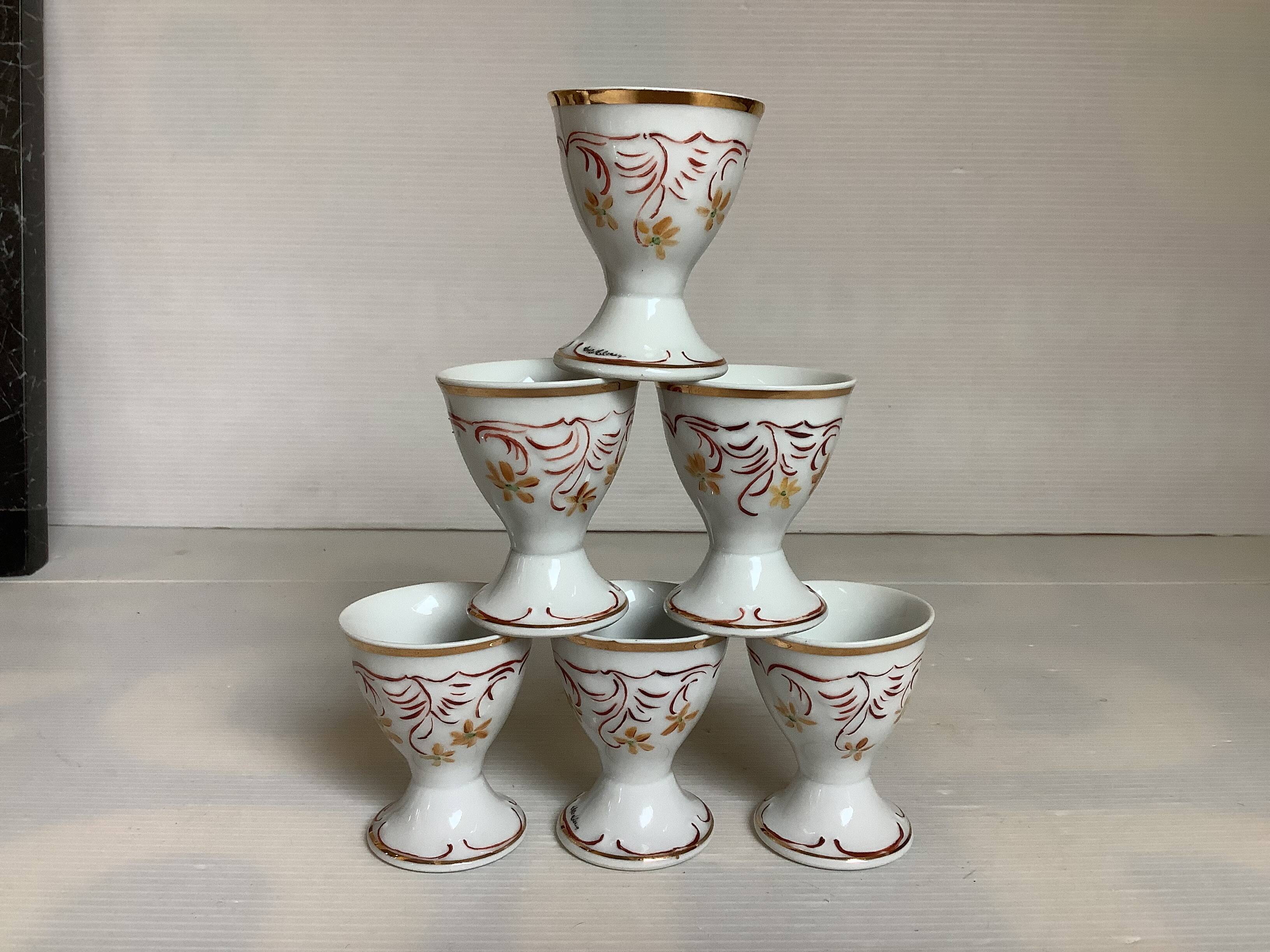 Six hand-decorated and signed egg cups