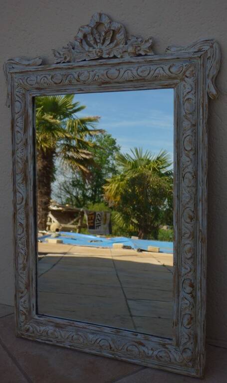 Chic and stylish old mirror with carved wooden frame in limed white and gold