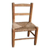 Antique wooden child's chair with a straw seat.