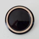 Vintage black ceramic candle holder on a bowl