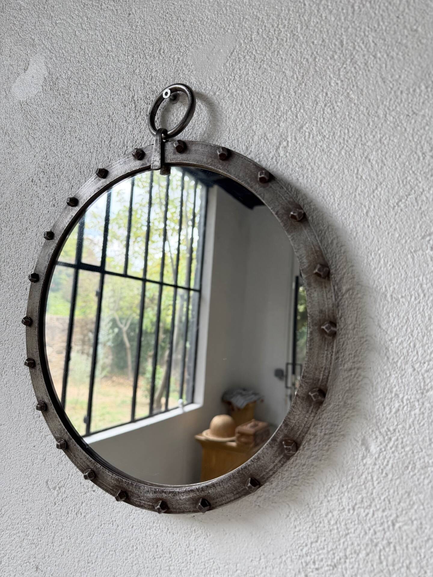 Brutalist round mirror with wrought iron and studs.