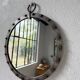 Brutalist round mirror with wrought iron and studs.