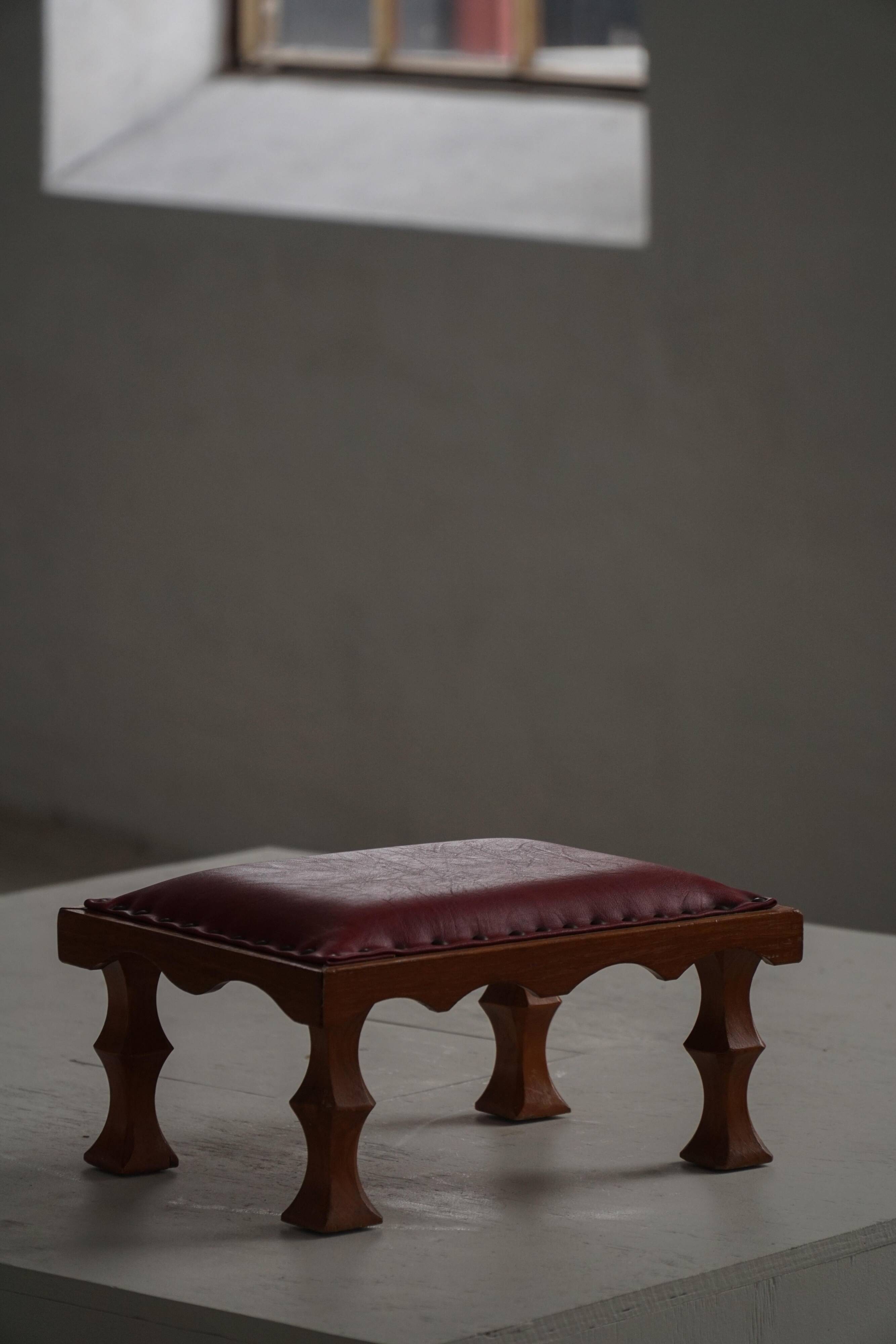 Danish sculpted oak stool from the mid-20th century with a red leather seat, 1950s.