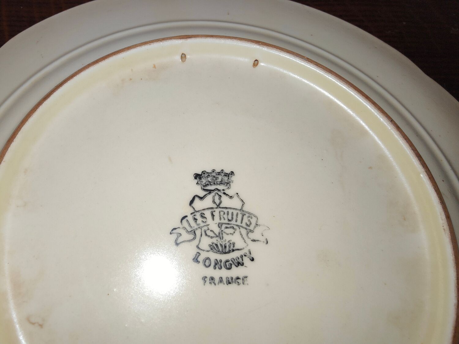 Faience plate in Longwy enamels signed Léa Valenti representing Fruits