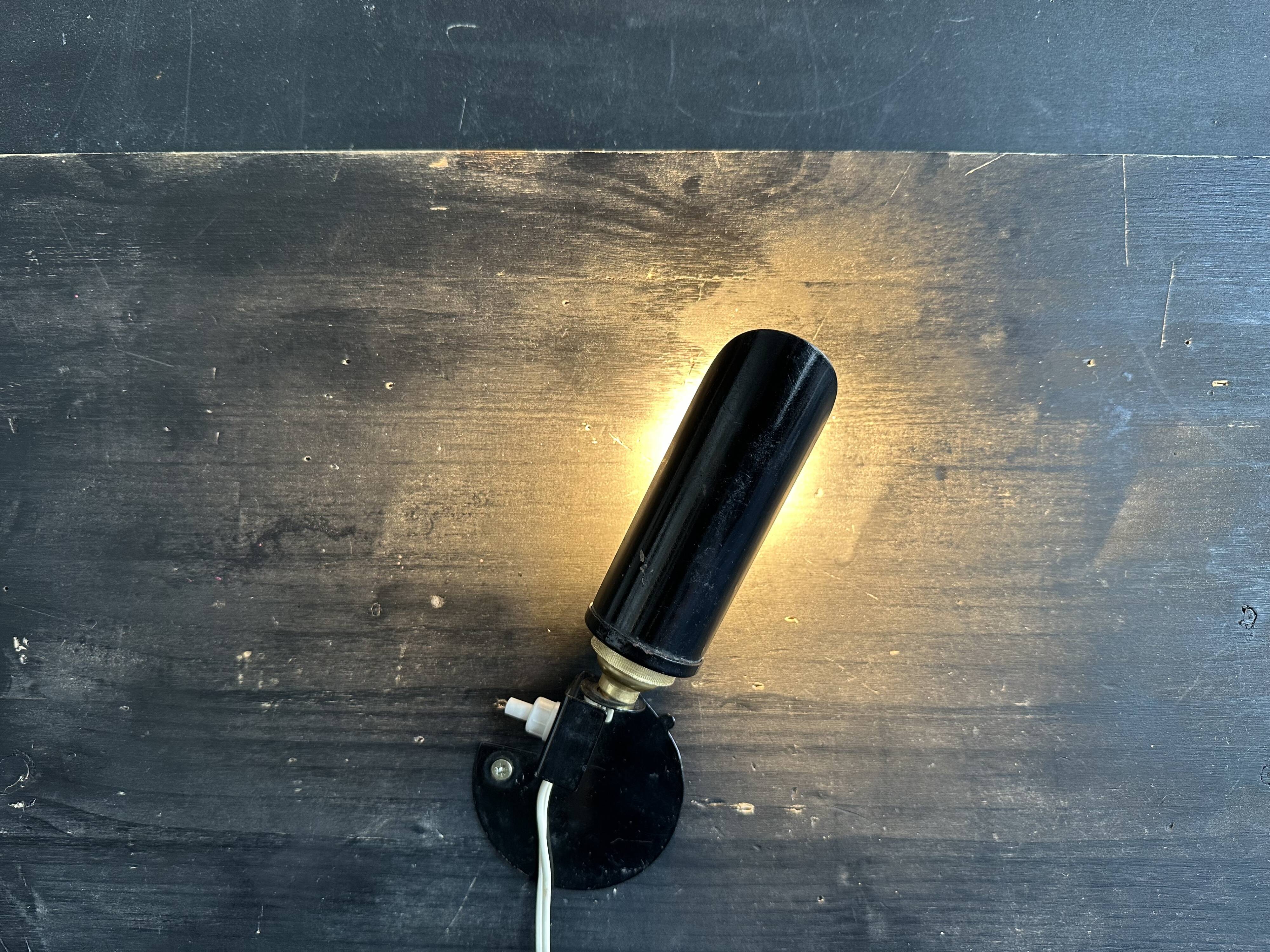 Old black metal and brass wall light, adjustable, 1930s.