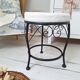 Black iron stool/pouf with its boucle fabric cushion.