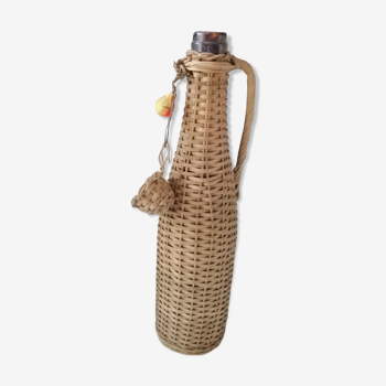 Old bottle surrounded by rattan wicker