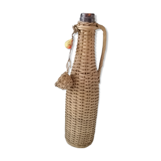 Old bottle surrounded by rattan wicker